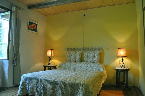 Chambre Jaune avec literie blanche et lumière naturelle